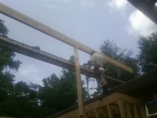 Carpenter setting a ridge beam over a new addition frame — Ice Dam Removal by Roofing Brothers in Iron Station