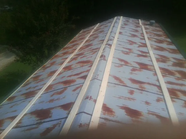 Rusted metal roof panels with new wood purlins before replacement — Storm Damage Roof Repair in Iron Station by Roofing Brothers