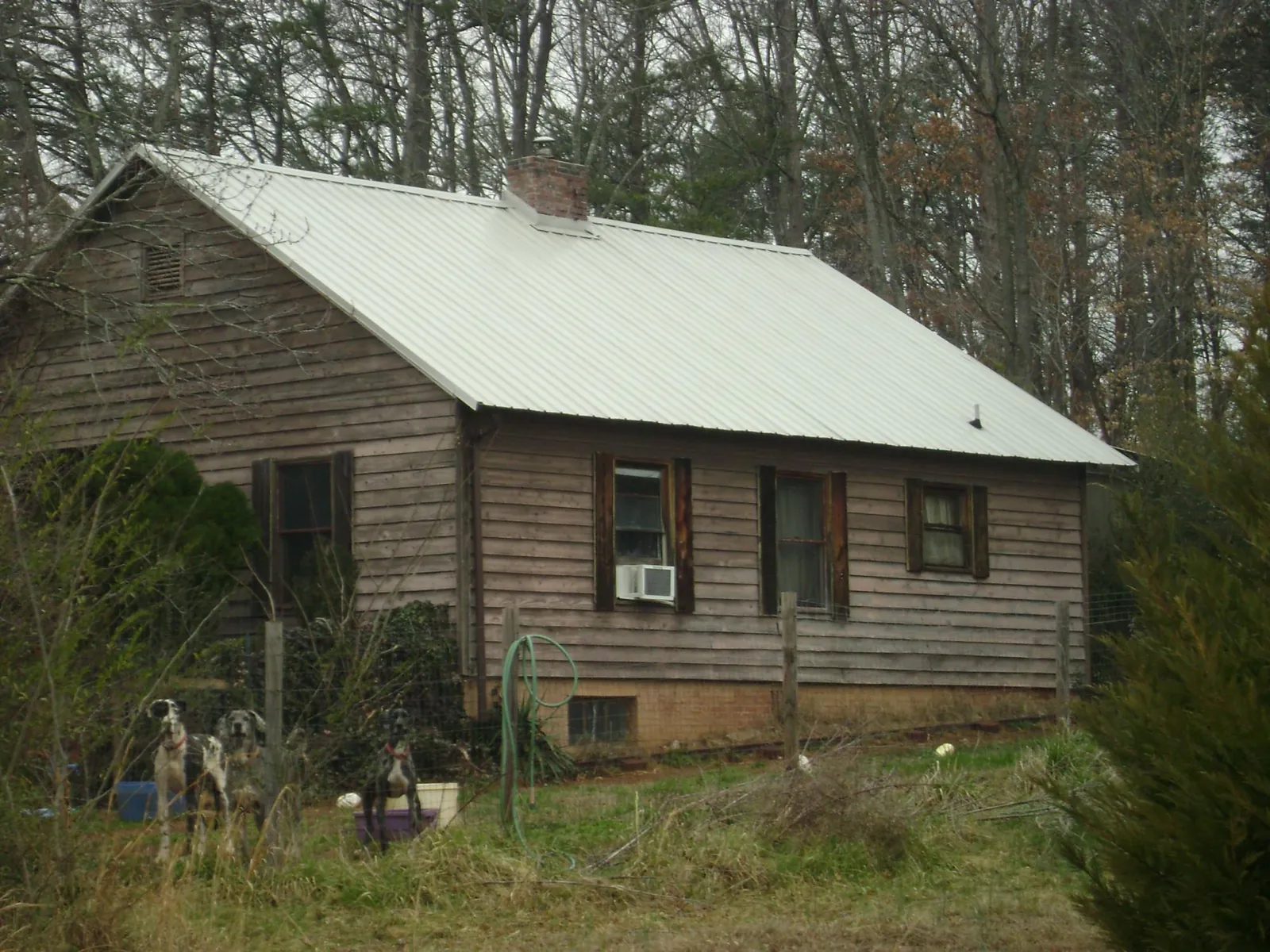 White metal roof on an old wood sided farmhouse, from a Metal Roof Installation job in Iron Station